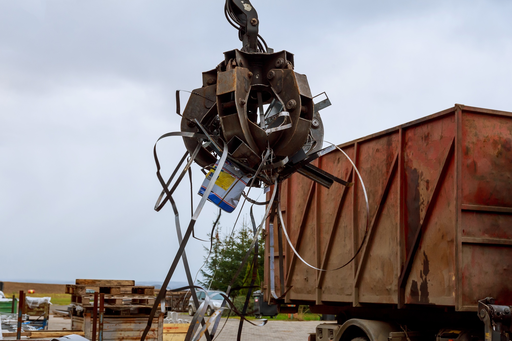 Loading scrap metal into a truck. Crane grabber loading metal rusty scrap in the dock