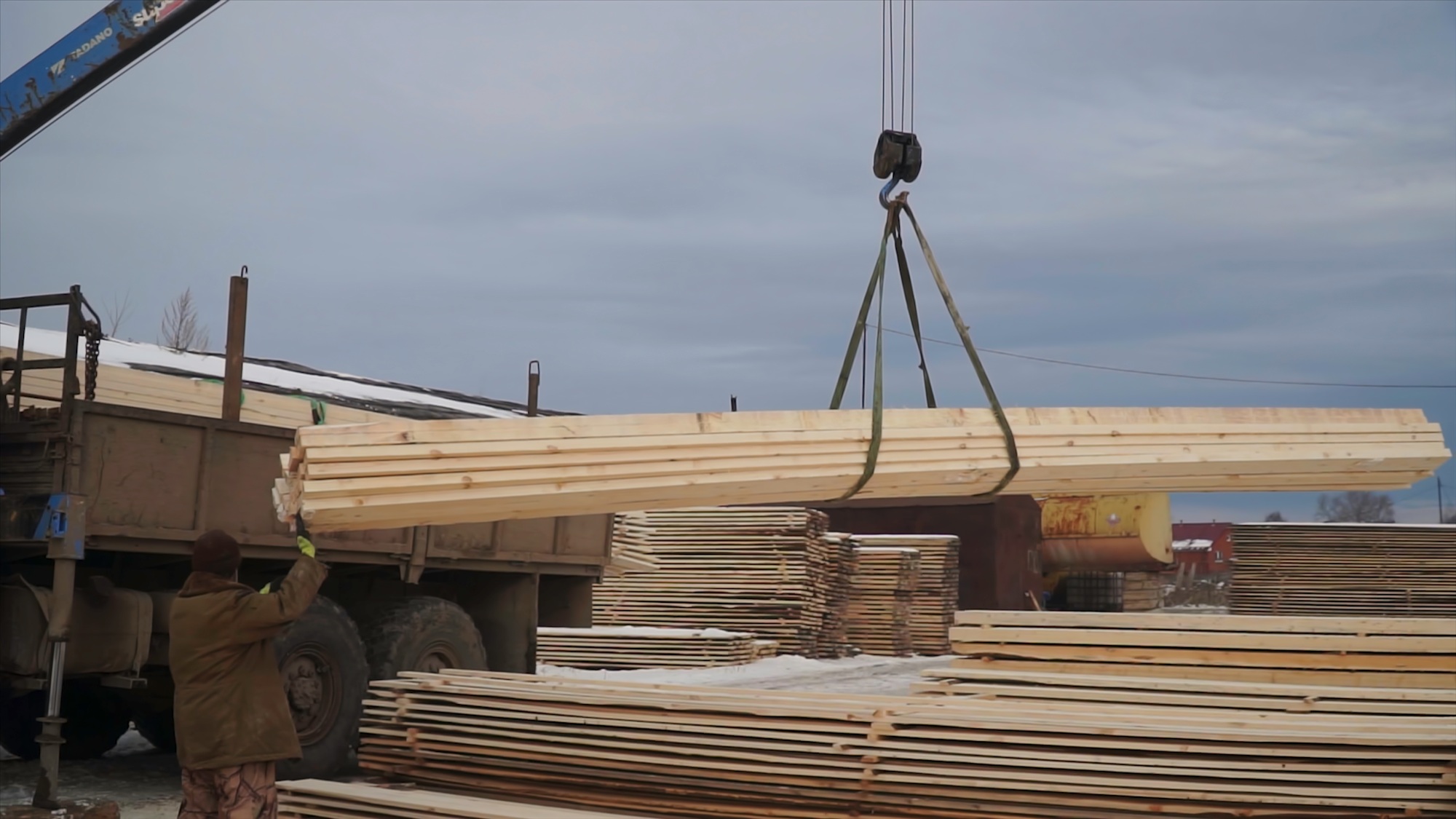 Wooden planks are lifted by crane for transportation. Clip. Loading of wooden boards for